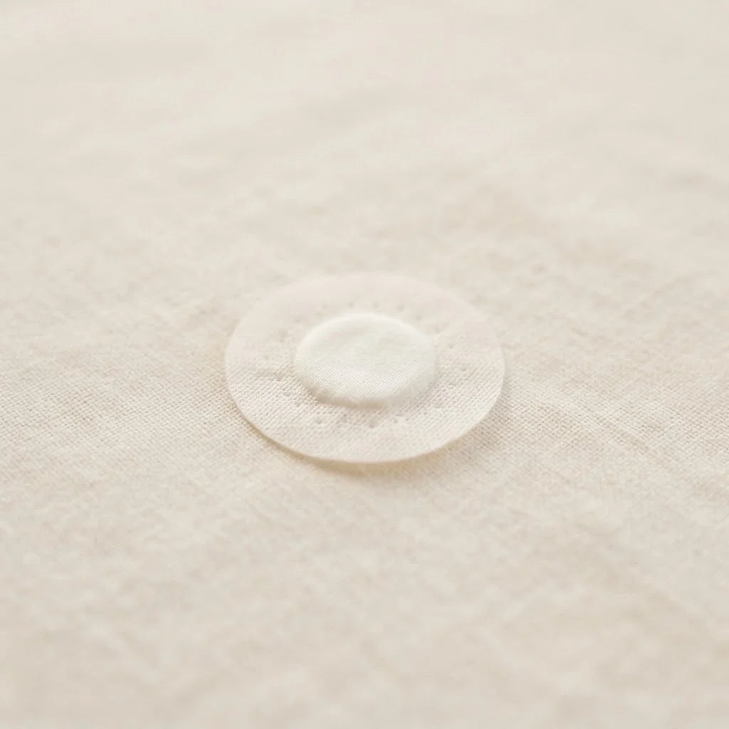 Pansement blanc posé seul, illustrant la question du bain de bébé après une vaccination